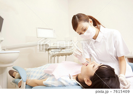 歯科衛生士と治療を受ける女性患者 7615409