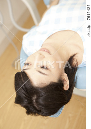 歯科のリクライニングチェアに横たわる女性 歯科のリクライニングチェアに横たわる女性 7615425