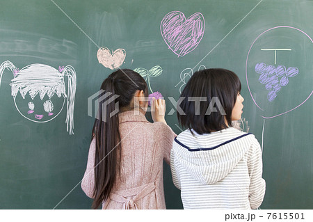 黒板に絵を描く小学生女子 7615501
