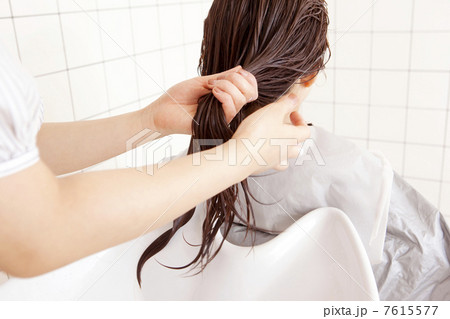 美容師にトリートメントをつけてもらう女性 美容師にトリートメントをつけてもらう女性 7615577