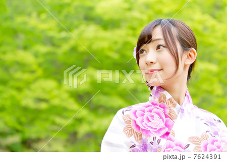 夏の森林で可愛らしいピンクの浴衣を着た可愛らしい女の子の写真素材