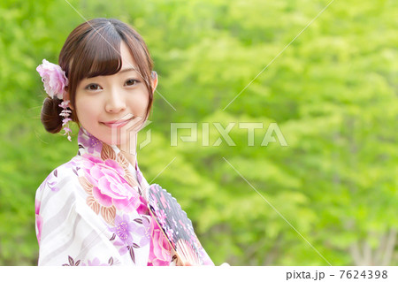 新緑が眩しい森の中でカメラ目線で微笑む可愛い女の子 7624398