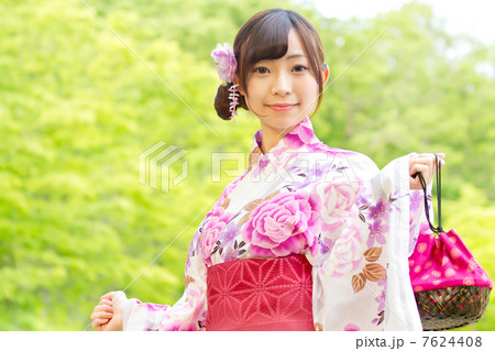 新緑の綺麗な森を背に巾着を持って可愛らしいポーズをする浴衣の女性 新緑の綺麗な森を背に巾着を持って可愛らしいポーズをする浴衣の女性 7624408