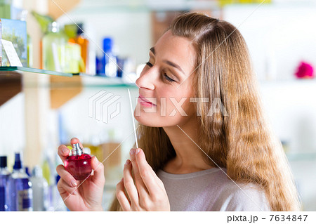 woman buying perfume in shop or store 7634847