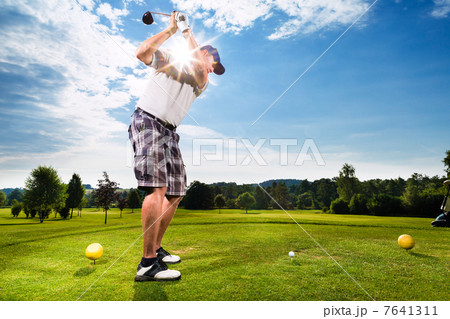 Young golf player on course doing golf swing Young golf player on course doing golf swing 7641311