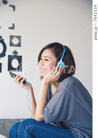 Asian Young Woman Wearing Headphones with Deco background Asian Young Woman Wearing Headphones with Deco background 7642534