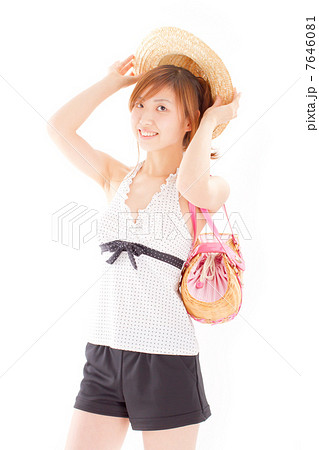 麦わら帽子に手を添えるお洒落な水着を着た女の子の写真素材