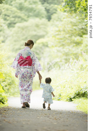 手をつなぐ親子の後姿の写真素材