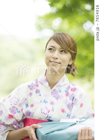 お中元を持ち微笑む浴衣姿の女性 お中元を持ち微笑む浴衣姿の女性 7654916