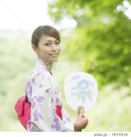 うちわを持ち微笑む浴衣姿の女性 7654918