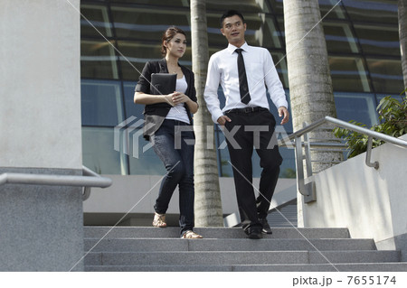 Asian Business Man and Woman Walking Down Steps 7655174