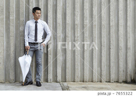 Asian business man leaning on a wall 7655322