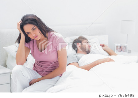 Anxious woman thinking while she is sat in her bed 7656498