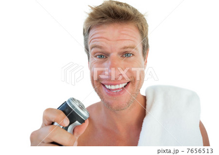 Handsome man holding an electric razor Handsome man holding an electric razor 7656513