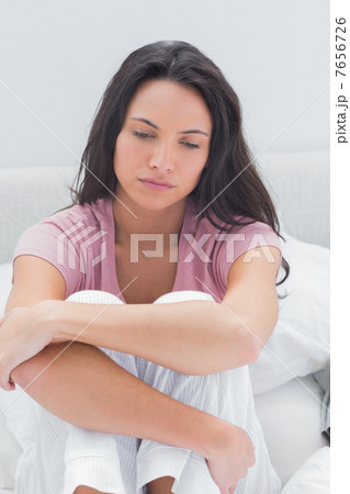 Anxious woman sat on her bed Anxious woman sat on her bed 7656726