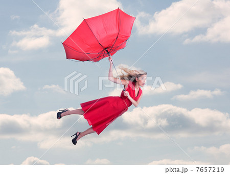 Attractive woman flying in the blue sky 7657219