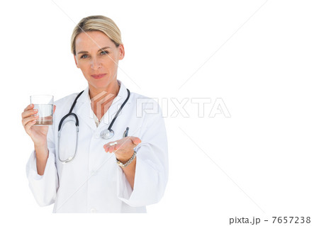Happy doctor holding out drugs and water glass 7657238
