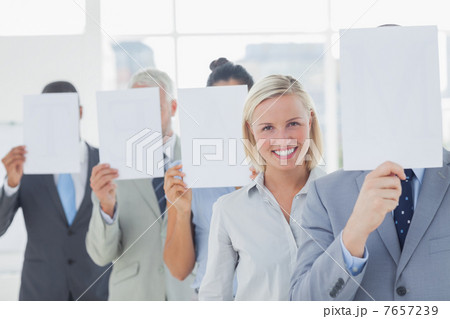 Business team covering face with white paper except for one woma Business team covering face with white paper except for one woma 7657239