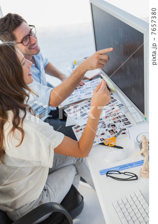 Attractive photo editors pointing at computer Attractive photo editors pointing at computer 7657380