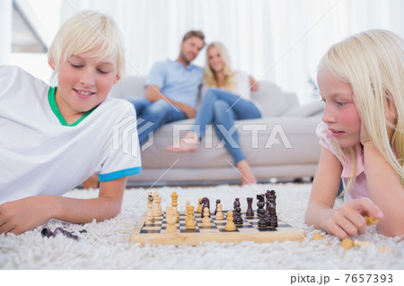 Children playing chess in the living room 7657393