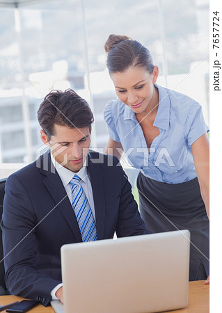 Business people smiling and working together with a laptop 7657724