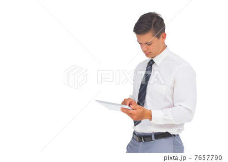 Frowning businessman using tablet 7657790