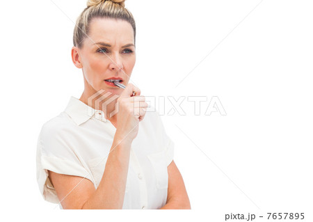 Focused businesswoman with pen on mouth Focused businesswoman with pen on mouth 7657895