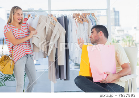 Depressed man looking at his shopaholic girlfriend Depressed man looking at his shopaholic girlfriend 7657995
