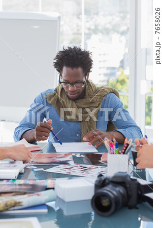 Photo editor brainstorming with his colleagues Photo editor brainstorming with his colleagues 7658026