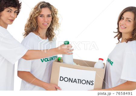 Volunteer women putting food in donation box 7658491