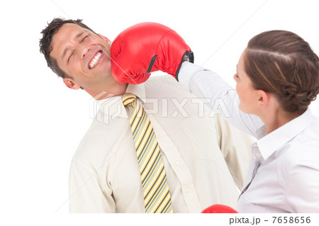 Businesswoman knocking out a businessman with boxing gloves Businesswoman knocking out a businessman with boxing gloves 7658656