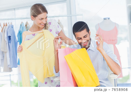 Man sitting in a boutique holding shopping bags Man sitting in a boutique holding shopping bags 7658908