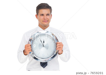 Anxious businessman holding a clock Anxious businessman holding a clock 7659201