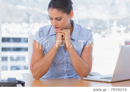 Pessimistic businesswoman sitting at her desk 7659214