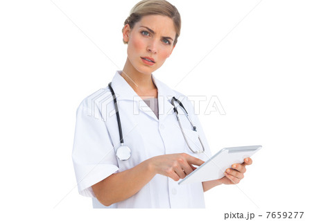 Annoyed nurse using tablet pc 7659277