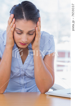 Unhappy businesswoman having her head in hands 7659337