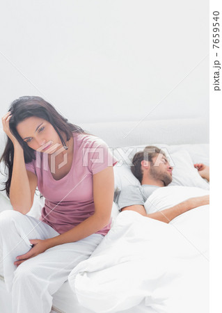 Stressed woman thinking while she is sat in her bed 7659540