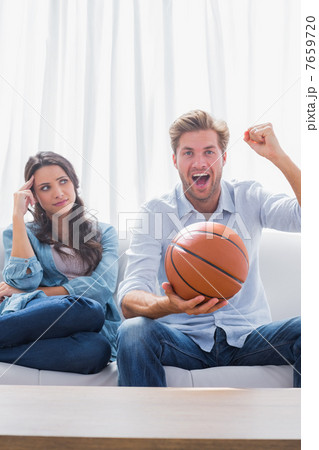 Woman looking at her husband cheering the basketball game Woman looking at her husband cheering the basketball game 7659720