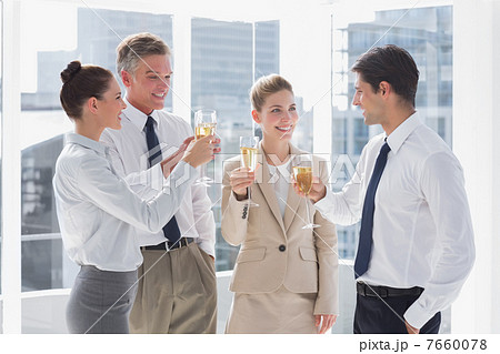 Smiling team of business people clinking their flutes of champag Smiling team of business people clinking their flutes of champag 7660078