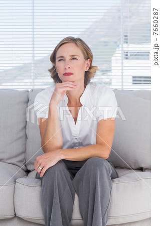Thinking businesswoman sitting on couch 7660287