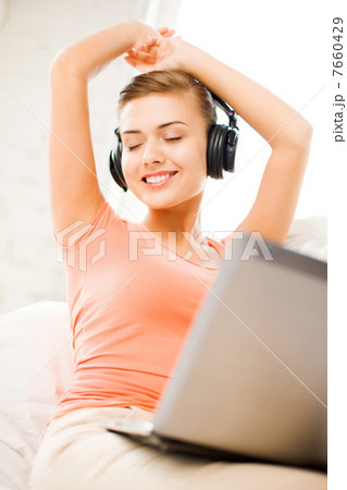 woman with headphones and laptop at home woman with headphones and laptop at home 7660429