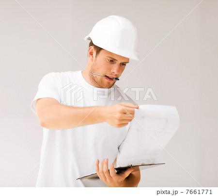 male architect looking at blueprint 7661771