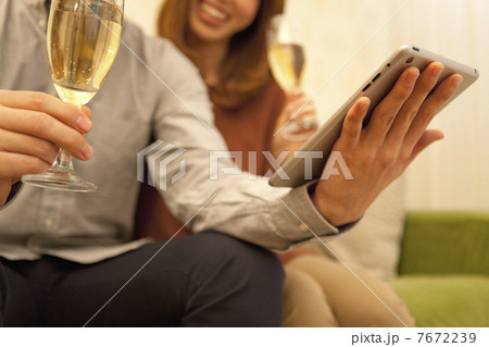 タブレットPCを見ているカップルの手元 7672239