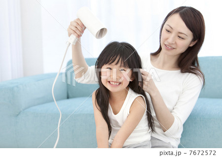 母親に髪を乾かしてもらう女の子 母親に髪を乾かしてもらう女の子 7672572