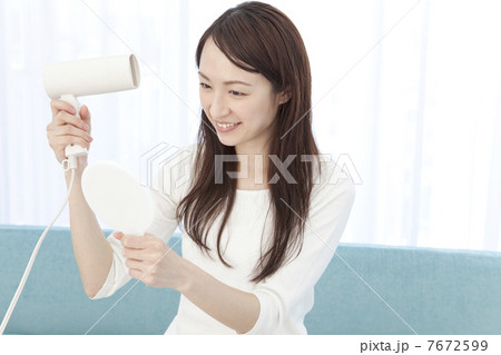 ドライヤーで髪を乾かす女性 7672599