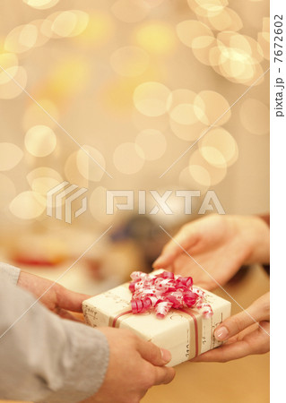 プレゼントを手渡す男女の手 7672602