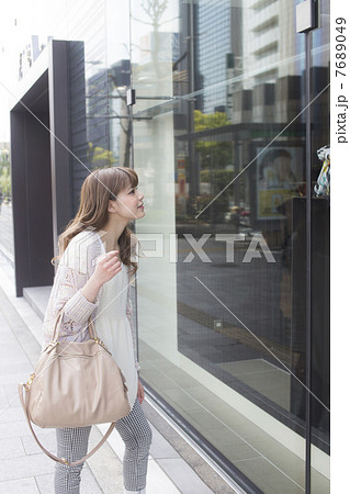 ウィンドウショッピングする若い女性 7689049