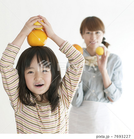 レモンとオレンジを持ち微笑む親子 7693227