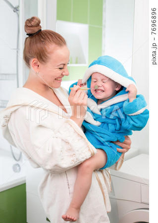 Happy mother and child teeth brushing together in bathroom Happy mother and child teeth brushing together in bathroom 7696896