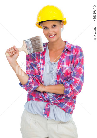 Attractive handy woman holding a brush and smiling at camera Attractive handy woman holding a brush and smiling at camera 7699645